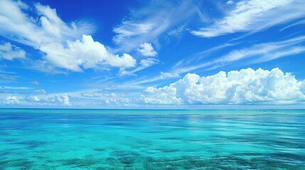 A beautiful scene of the blue ocean against the blue sky background. The ocean stretches out as far as the eye can see, with its surface glistening in the sunlight