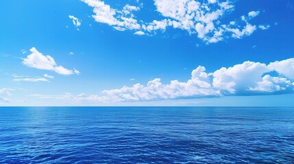 Wall Mural - A beautiful scene of the blue ocean against the blue sky background. The ocean stretches out as far as the eye can see, with its surface glistening in the sunlight