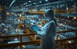 © yevgeniya131988 - Female worker in protective gear holding a tablet on a factory balcony with CNC machines