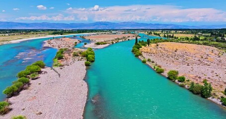 Wall Mural - Aerial view of clear river on the edge of desert. Curved river and green forest with mountain natural landscape in Xinjiang, China.