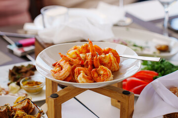 A plate of fried shrimp on a banquet table. A delicious and simple seafood appetizer.