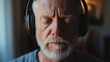 © vefimov - Middle-aged man with headphones, eyes closed in relaxation or concentration.