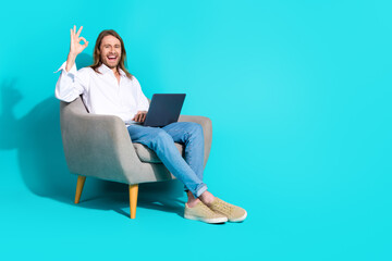 Poster - Full length photo of funky cool guy dressed white shirt showing okey texting modern device emtpy space isolated teal color background