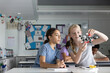 © ReeldealHD images - Two girl students in science class looking at a molecular model together