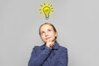 © millaf - Pretty thinking child girl with light bulb on white background. Education and idea concept
