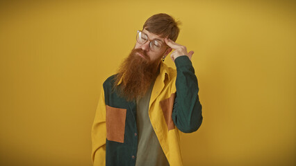 Wall Mural - Pensive redhead man with beard contemplating isolated over yellow background