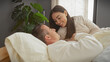 © Krakenimages.com - A loving couple enjoys a tender moment while relaxing together in a cozy bedroom setting, portraying intimacy and affection.