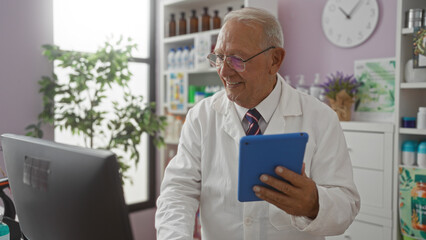 Sticker - An elderly caucasian man, smiling in a pharmacy, works on a tablet dressed in a white lab coat with shelves of medicine in the background.