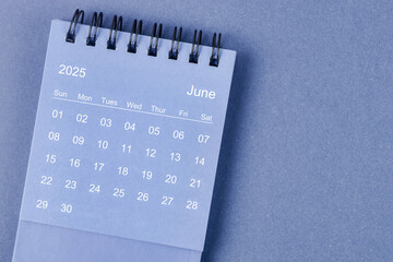 june 2025 monthly desk calendar for 2025 year on blue background.