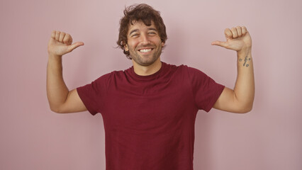 Wall Mural - Handsome young hispanic man with a beard smiling and pointing at himself, isolated against a pink wall background.