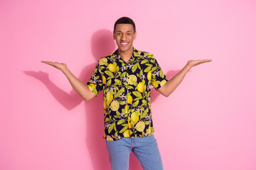 Wall Mural - Photo portrait of attractive young man hold compare empty space dressed stylish tropical print clothes isolated on pink color background