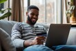 © Vooglo.com - A man lounging comfortably in a modern living room, holding a credit card in one hand while