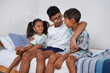 © Caia Image - Siblings sitting on bed
