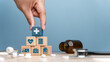 © Benjamas - Health care and Health insurance concept. Benefits of health insurance, medical expenses, providing financial security. hand arranging wood block, health insurance icon  on wood block.