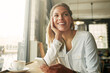 © ThurstanJam/peopleimages.com - Woman, relax and thinking with smartphone in coffee shop for social media ideas, blog post update or inspiration. Person, smile and phone in restaurant for checking notification, chat and daydreaming
