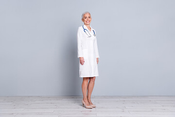 Canvas Print - Full length photo of attractive senior lady qualified specialist doctor therapist wear white robe isolated on grey color background