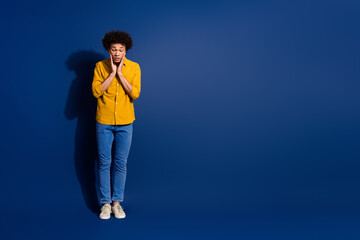 Sticker - Full body portrait of nice young man look down empty space wear yellow shirt isolated on dark blue color background