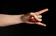 © bergamont - heavy metal hand gesture on black background