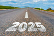 © ARVD73 - The goal word calendar 2025 written on highway road in the middle of empty asphalt road at golden sunset and beautiful blue sky. Concept for year 2025.