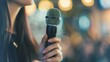 © Татьяна Кузнецова - A person holding a microphone in a vibrant, illuminated setting during a public speaking event in the evening
