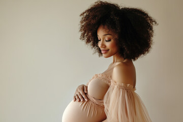 Wall Mural - Pregnant woman with afro hair style is caressing her belly and smiling