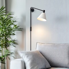 Wall Mural - Modern wall lamp with white cone shade illuminates a grey sofa and green plant.