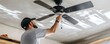 © doraclub - Handyman Installing Ceiling Fan for Home Modernization and Energy Efficiency