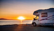 © anandart - Table background with a wooden board and sunny beach and ocean and a camper van