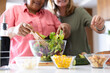 © Wavebreak Media - At home, preparing fresh salad, two senior multiracial female friends in kitchen
