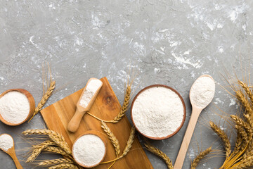 Wall Mural - Flat lay of Wheat flour in wooden bowl with wheat spikelets on colored background. world wheat crisis