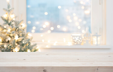 Wall Mural - blur christmas tree and decorated window interior background with wooden table top for product displ