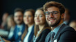 © Sunny - A group of business people at a conference or meeting, sitting in arow and listening to a presentation. Highlighting the focus and engagement of attendees.