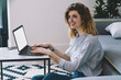 © BullRun - Happy smiling female student preparing to university course work using laptop application for making research of information, positive woman sitting at desktop with netbook with mock up screen