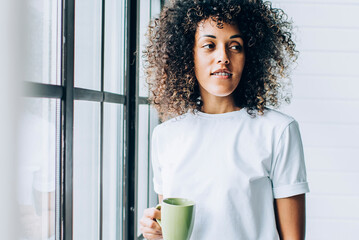 Wall Mural - Stylish ethnic woman with coffee near window