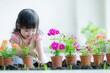 © Alena - A young girl is having fun playing with some colorful flowers in a sunny outdoor setting