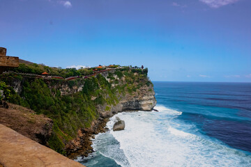 Uluwatu cliff and temple panorama landscape with huge waves at the beach. Bali sea beach nature, outdoor Indonesia. Travel to Bali island landscape. 