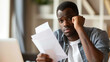 © ki - Concerned man at desk holding stack of papers symbolizing financial stress and national debt, captured in soft bokeh background emphasizing emotion and tension.