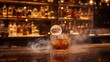 © Sirilak - A whiskey cocktail with a spherical ice cube, set in a bar.