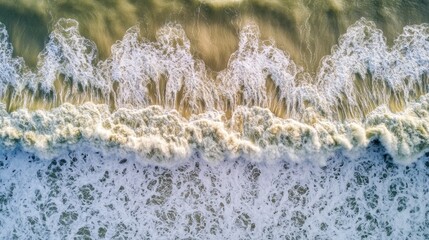 Wall Mural - Aerial view of ocean waves crashing onto the shore, showcasing natural beauty and movement.