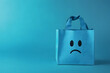 © Ana - Blue bag with sad face on blue background. Blue monday concept. Copy space