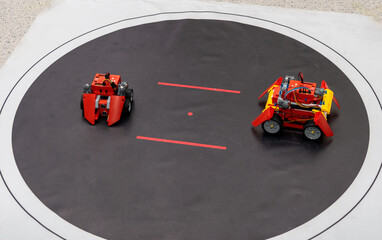 two robots in a black ring participate in robotics competitions