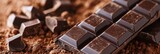 A detailed close-up image showcasing dark chocolate bars with cocoa powder scattered around.