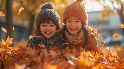 Canvas Print - Two children laughing in a pile of autumn leaves.