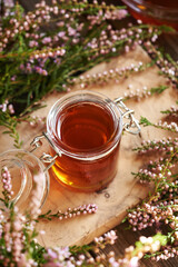 Canvas Print - Herbal syrup in a glass jar with fresh wild heather flowers harvested in the forest