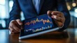 © Johannes - Businessman using tablet analyze sales data and economic growth graph chart