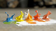 © n3wttfoto - A colorful paint splatter on a white surface with five different colors