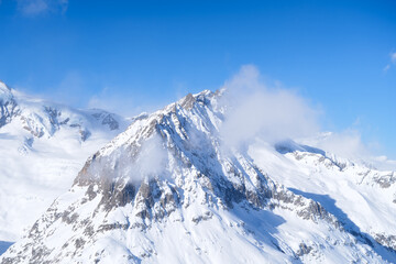 Wall Mural - Switzerland. Winter mountain landscape. Wallpaper or background. Cold weather and frost. High rocks and snow. View of mountains.