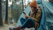 © Daniel - Woman using Smartphone in tent in the woods.