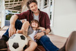 © Marko Geber - Father playing soccer with son on patio