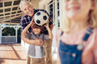 © Marko Geber - Grandfather playing soccer with grandson on patio